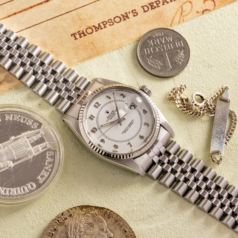 Eine Uhr auf Papieren und alten Münzen